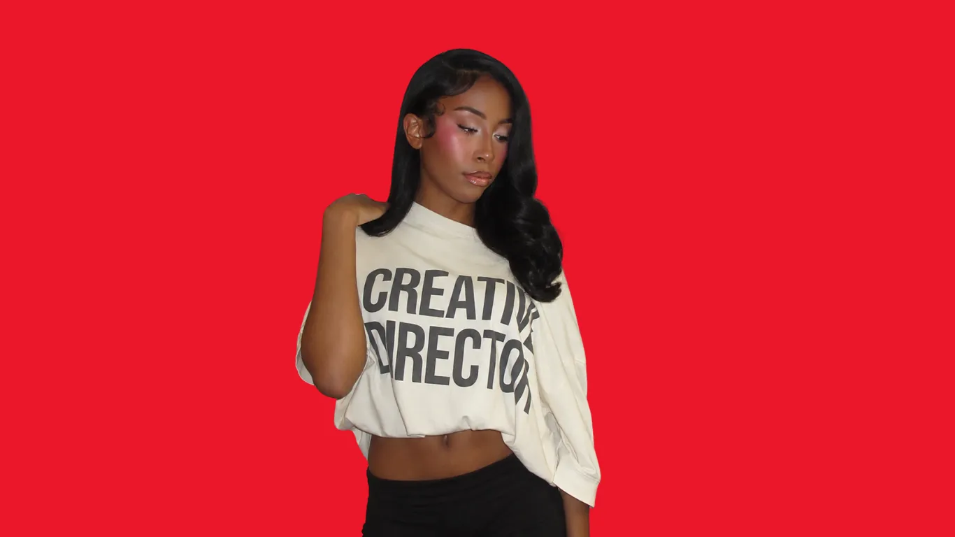 Marley Mullins looking over her shoulder in a cream Creative Director tee